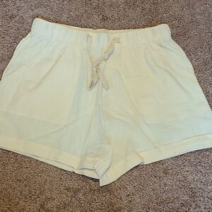 Linen paperbag shorts yellow with pink sewing marks looks cute and intentional.